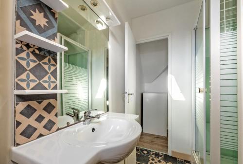 bagno bianco con lavandino e specchio di Menhir a Hôpital-Camfrout