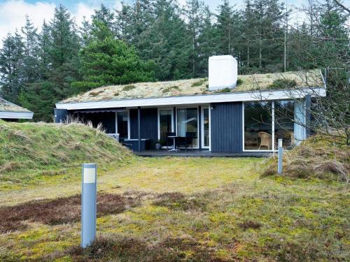 a house with a grass roof on top of a hill at 6 person holiday home in Blokhus-By Traum in Blokhus
