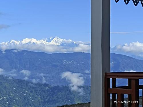 uma vista para as montanhas a partir de uma janela em Chewa Homestay em Mangpu