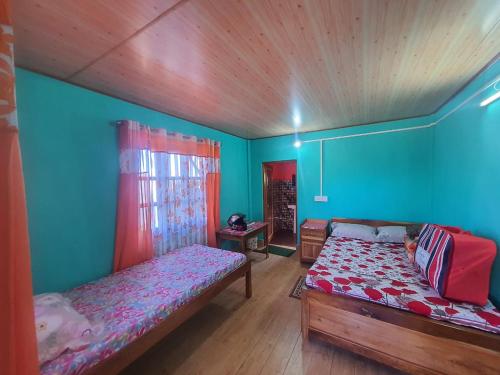 - une chambre avec 2 lits dans une chambre aux murs bleus dans l'établissement Chewa Homestay, à Mangpu