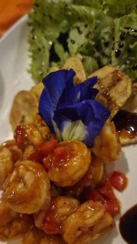 a white plate of food with shrimp and broccoli at Tablas Seaview Homestay in Ferrol