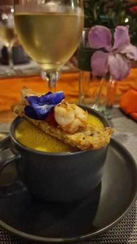 a black bowl of soup with a glass of wine at Tablas Seaview Homestay in Ferrol