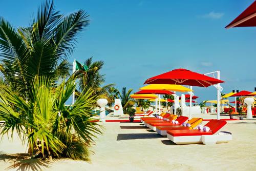 a row of chairs and umbrellas on a beach at voco Dubai Monaco, the Heart of Europe by IHG in Dubai