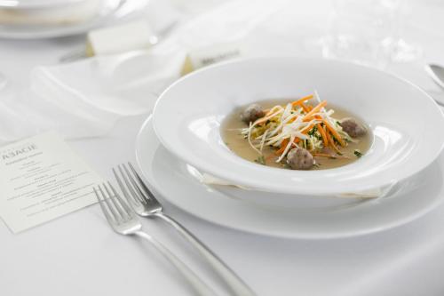 a plate of soup with meatballs and cheese on a table at Wellness Hotel ABÁCIE in Nový Jičín