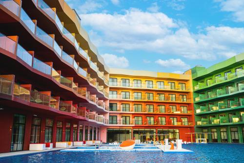 a row of colorful buildings with water in front at voco Dubai Monaco, the Heart of Europe by IHG in Dubai