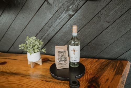 a bottle of wine sitting on top of a table at Lovers nest by Casa Oso with private hiking trails and pond in Mariposa