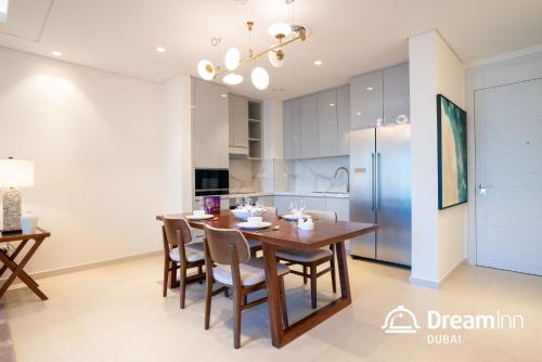 a kitchen and dining room with a wooden table and chairs at Dream Inn Apartments - Address Beach Residence Fujairah in Fujairah