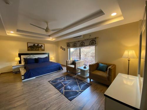 a bedroom with a bed and a couch and a chair at De-Meridian Luxury Apartments in Rawalpindi