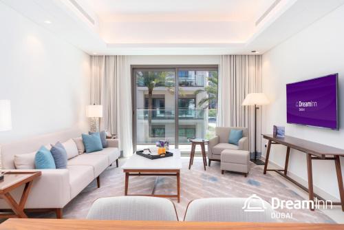 a living room with a couch and a tv at Dream Inn Apartments - Address Beach Residence Fujairah in Fujairah