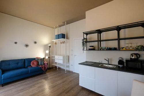 uma sala de estar com um sofá azul e uma cozinha em Verona Suites and Rooms em Verona
