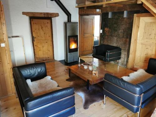 uma sala de estar com uma mesa e uma lareira em Sunny, rustical 5 room cottage in Valposchiavo em Poschiavo