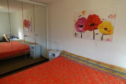 um quarto com uma cama vermelha e um espelho em Appartementhaus Onyx - zentrale, ruhige Lage - neu renoviert - mit Hallenbad - 600 Schritte vom Bahnhof em Muralto