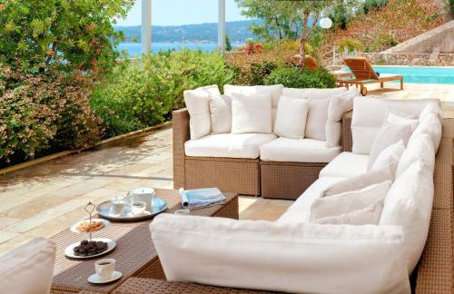 a patio with two white couches and a table at Corfu Luxury Villas in Barbati