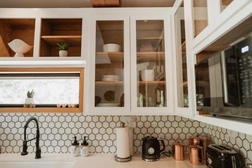 a kitchen with white cabinets and a sink at Lovers nest by Casa Oso with private hiking trails and pond in Mariposa