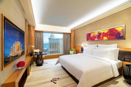 a hotel room with a large bed and a large window at Galaxy Macau in Macau
