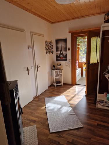 a living room with a wooden floor and a door at Knusperhäuschen Maria Nikoletta in Witra
