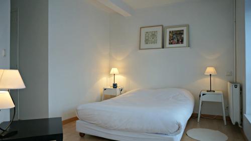 - une petite chambre avec un lit blanc et deux lampes dans l'établissement Little Suite - Jean, à Lille