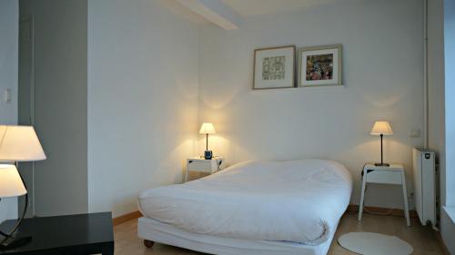 a small bedroom with a white bed and two lamps at Little Suite - Jean in Lille