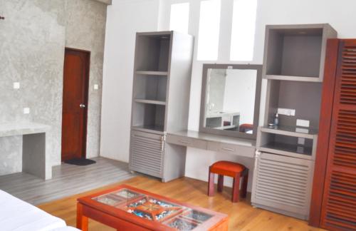 Cette chambre comprend une coiffeuse avec un miroir et une table. dans l'établissement Luxury Rooms Cinnamon Nature Resort, à Beruwala