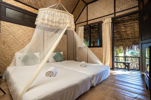a bedroom with a bed with a mosquito net at Jirung Health Village in Mae Rim
