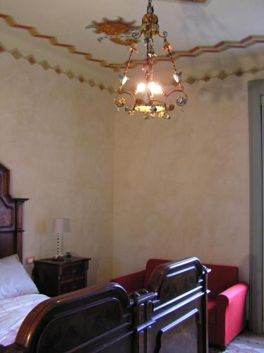 a bedroom with a bed and a chandelier at Bed & Breakfast Villa Palma in Lovere