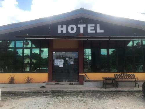 a hotel with a bench in front of it at Lily Budget Hotel in Jertih