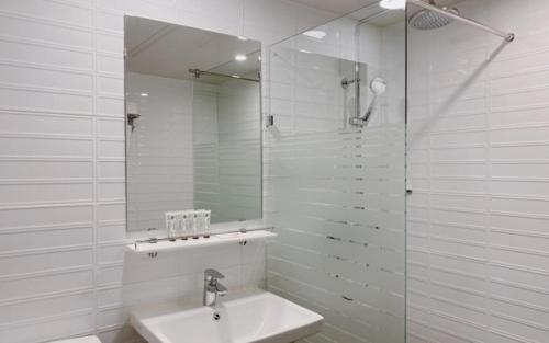 a white bathroom with a sink and a mirror at Gyeongpo Soo Hotel in Gangneung