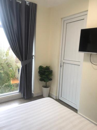 a door with a curtain and a plant in a room at Hue Four Seasons Hotel in Hue