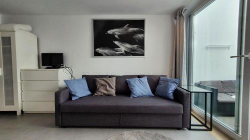 a living room with a couch with blue pillows at Beautiful Studio With Patio Carrapateira in Carrapateira
