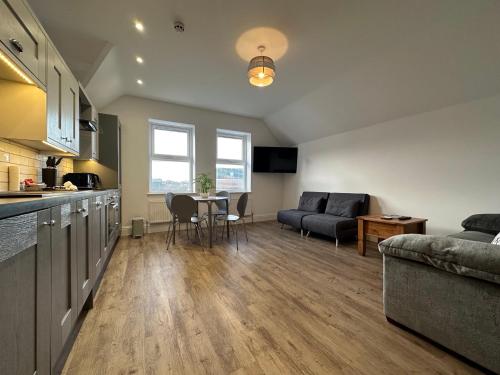 a kitchen and living room with a couch and a table at Brooklands Filey Seaside Retreat Flat 6 in Filey