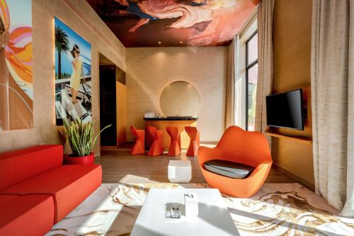 a living room with orange furniture and a tv at voco Dubai Monaco, the Heart of Europe by IHG in Dubai