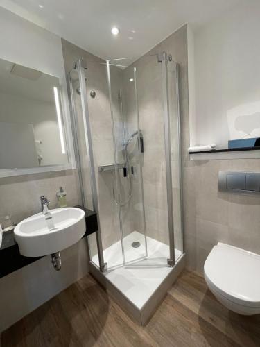 ein Bad mit einer Dusche, einem Waschbecken und einem WC in der Unterkunft Hotel Niedersächsischer Hof in Goslar