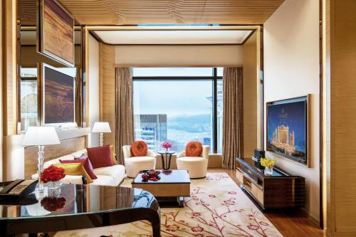 uma sala de estar com um sofá e uma grande janela em Galaxy Macau em Macau
