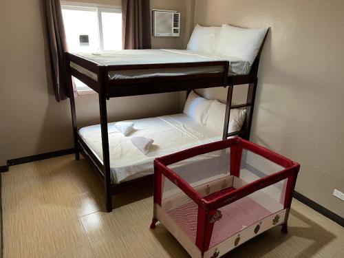 two bunk beds in a room with a window at Townes Huge Home Big Grps Big Fam Near SM Ecoland DGT Coastal road ADDU UM in Davao City