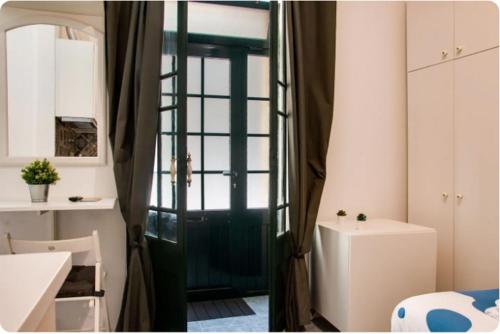baño con puerta, lavabo y espejo en Campolide Green Door Studio en Lisboa