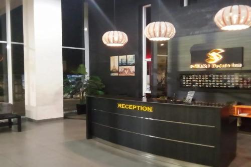 a hotel lobby with a reception desk and chandeliers at Smart Dream Aeropolis AR2 in Teko