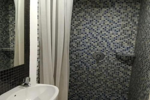 La salle de bains est pourvue d'un lavabo et d'une douche avec un miroir. dans l'établissement Smart Dream Aeropolis AR2, à Teko