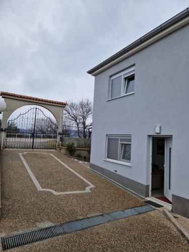 a white house with a basketball court in front of it at Grbaste51-Svilno,Rijeka in Rijeka