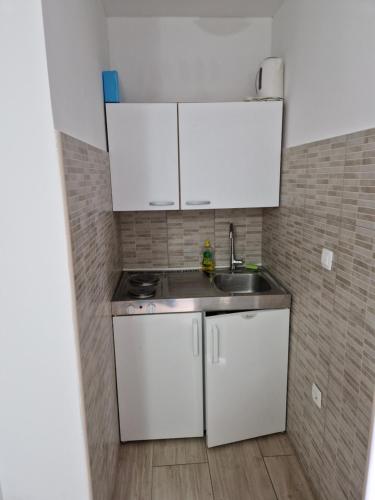 a small kitchen with white cabinets and a sink at Grbaste51-Svilno,Rijeka in Rijeka