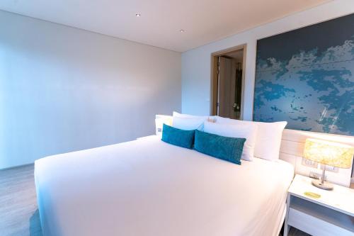 a bedroom with a large white bed with blue walls at Centra by Centara Maris Resort Jomtien - SHA Extra Plus in Jomtien Beach