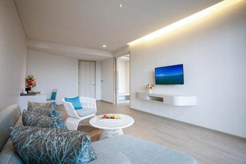 a living room with a couch and a tv on a wall at Centra by Centara Maris Resort Jomtien - SHA Extra Plus in Jomtien Beach