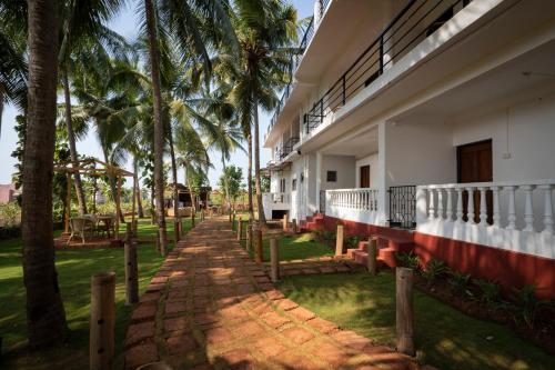 a building with palm trees in front of it at De Lavender Luxury sea view Guest Houses in Agonda