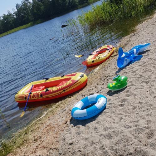 a group of boats on the shore of a body of water at Timber house with private beach and boat including. in Njurundabommen