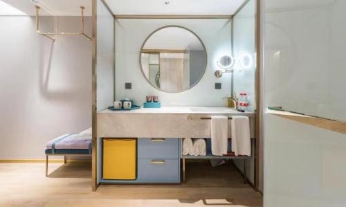 a bathroom with a sink and a mirror at Manxin Hotel Guangzhou Baiyun Airport Branch in Guangzhou