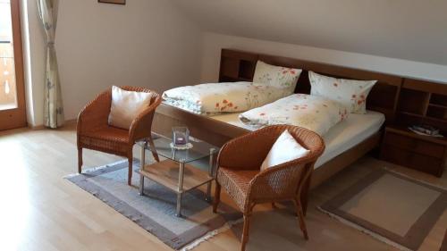 um quarto com uma cama com 2 cadeiras e uma mesa em Große Wohnung in Fürsteneck mit Grill und Terrasse em Fürsteneck