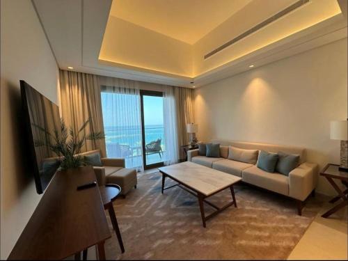 a living room with a couch and a table at Address Beach Resort Fujairah Apartment 2 Bed Rooms and Small Bed Room - Ground Floor 3011 in Al Aqah