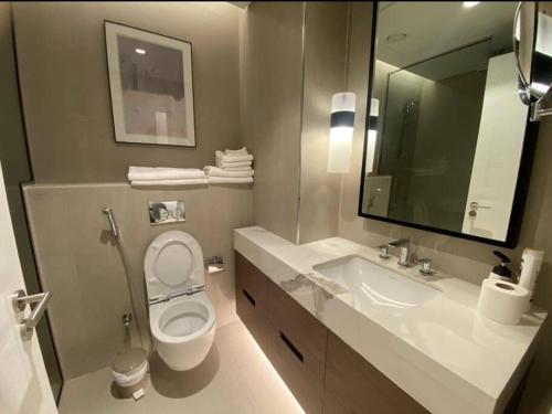 a bathroom with a toilet and a sink and a mirror at Address Beach Resort Fujairah Apartment 2 Bed Rooms and Small Bed Room - Ground Floor 3011 in Al Aqah
