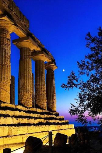 a view of a building with columns at night at The Garden House alla Scala dei Turchi in Realmonte