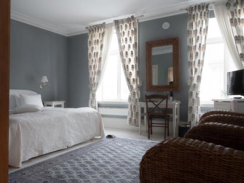 a bedroom with a bed and a mirror and a chair at Grand Hotel Marstrand in Marstrand