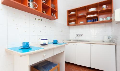 eine Küche mit weißen Schränken und blauen Geschirr auf den Tresen in der Unterkunft Apartment Capitano Blue in Dubrovnik